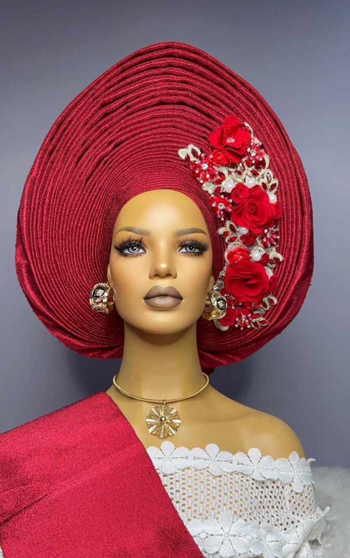 Front view of Red embellished asooke auto gele pre tied ready to wear nigerian bridal headwrap for traditional wedding on a mannequin.