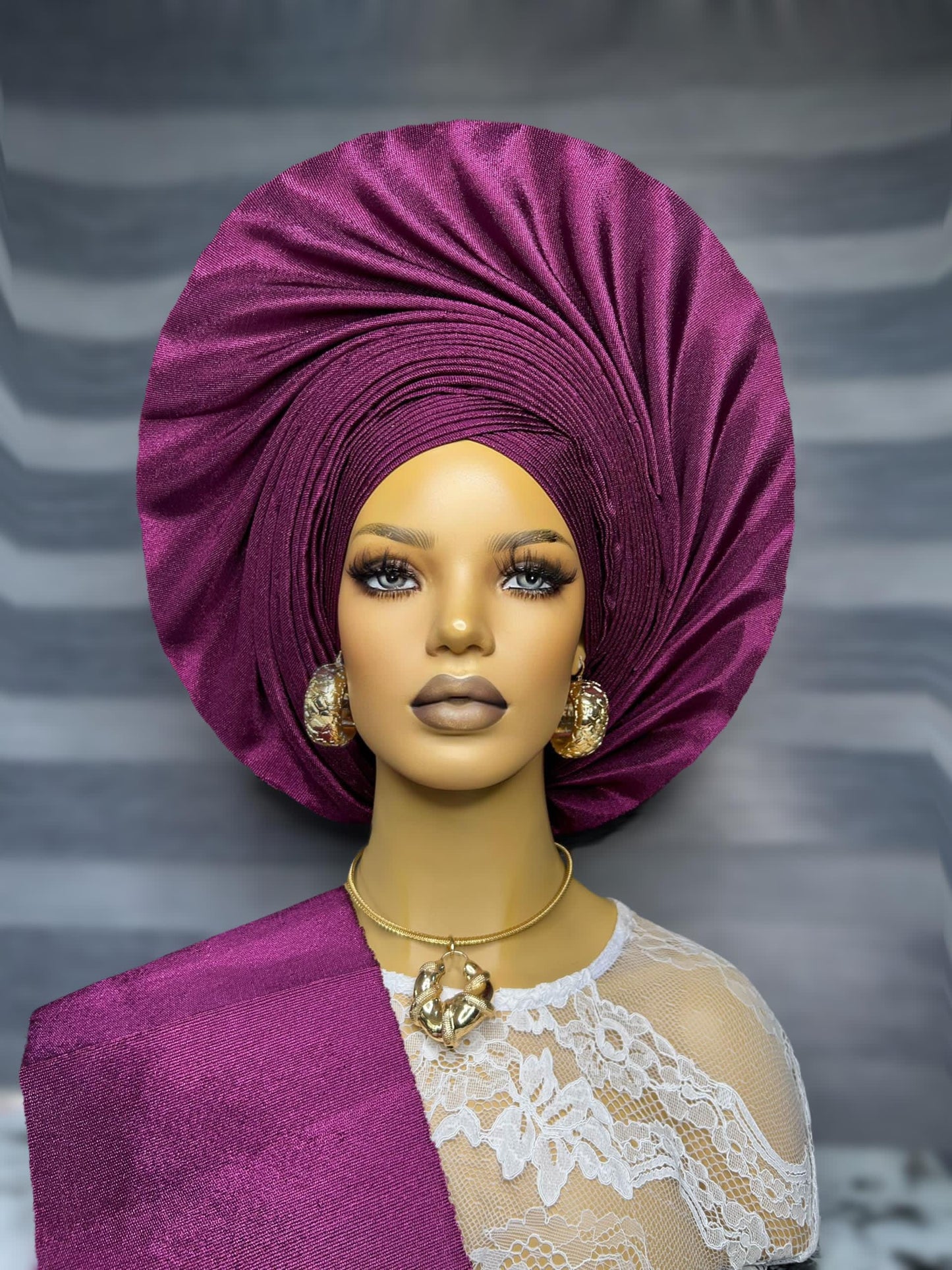 Front view purple asooke auto gele pre tied ready to wear nigerian bridal headwrap for traditional wedding on a mannequin.
