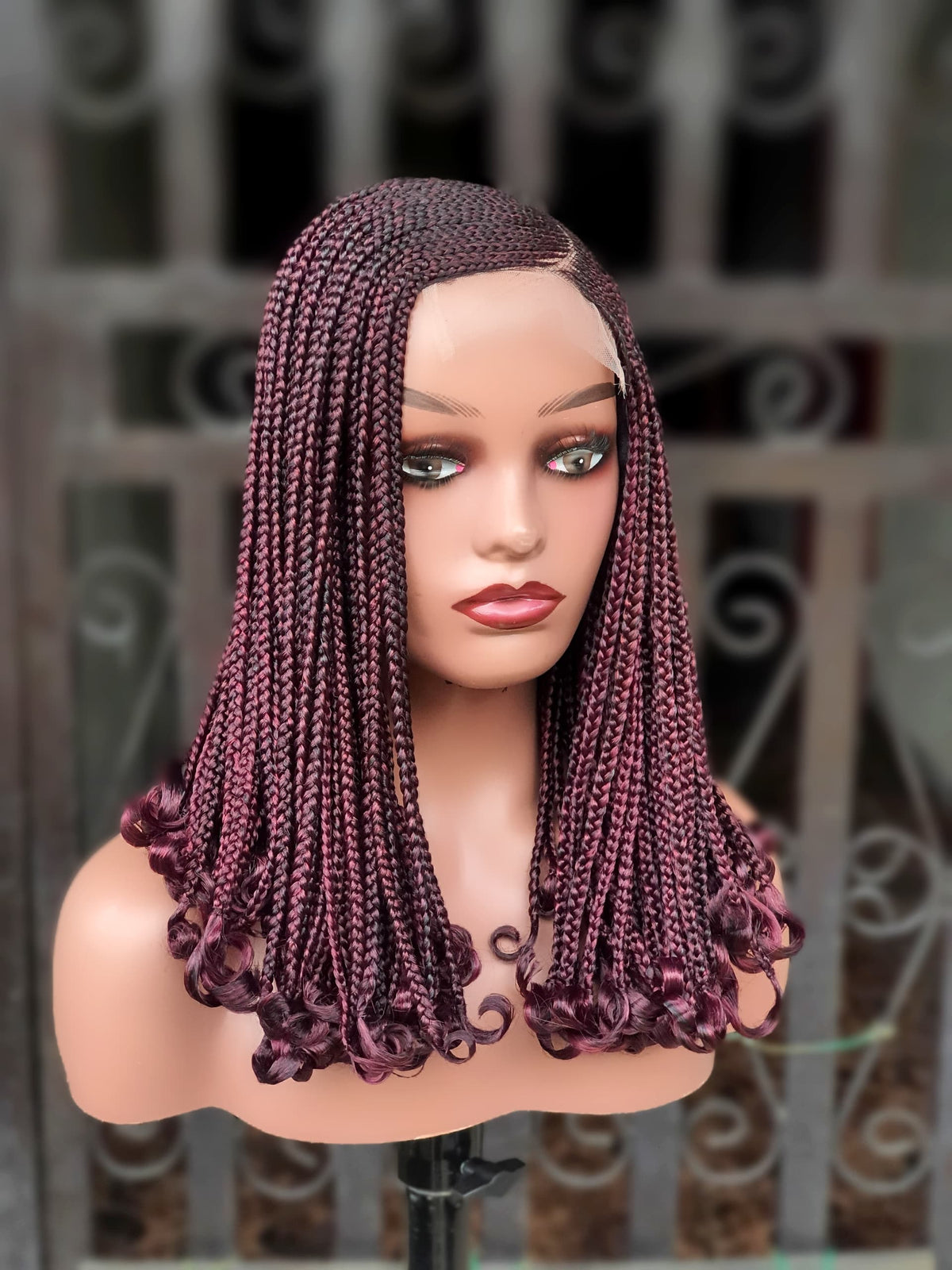 Front view of burgundy braided wig with curled ends