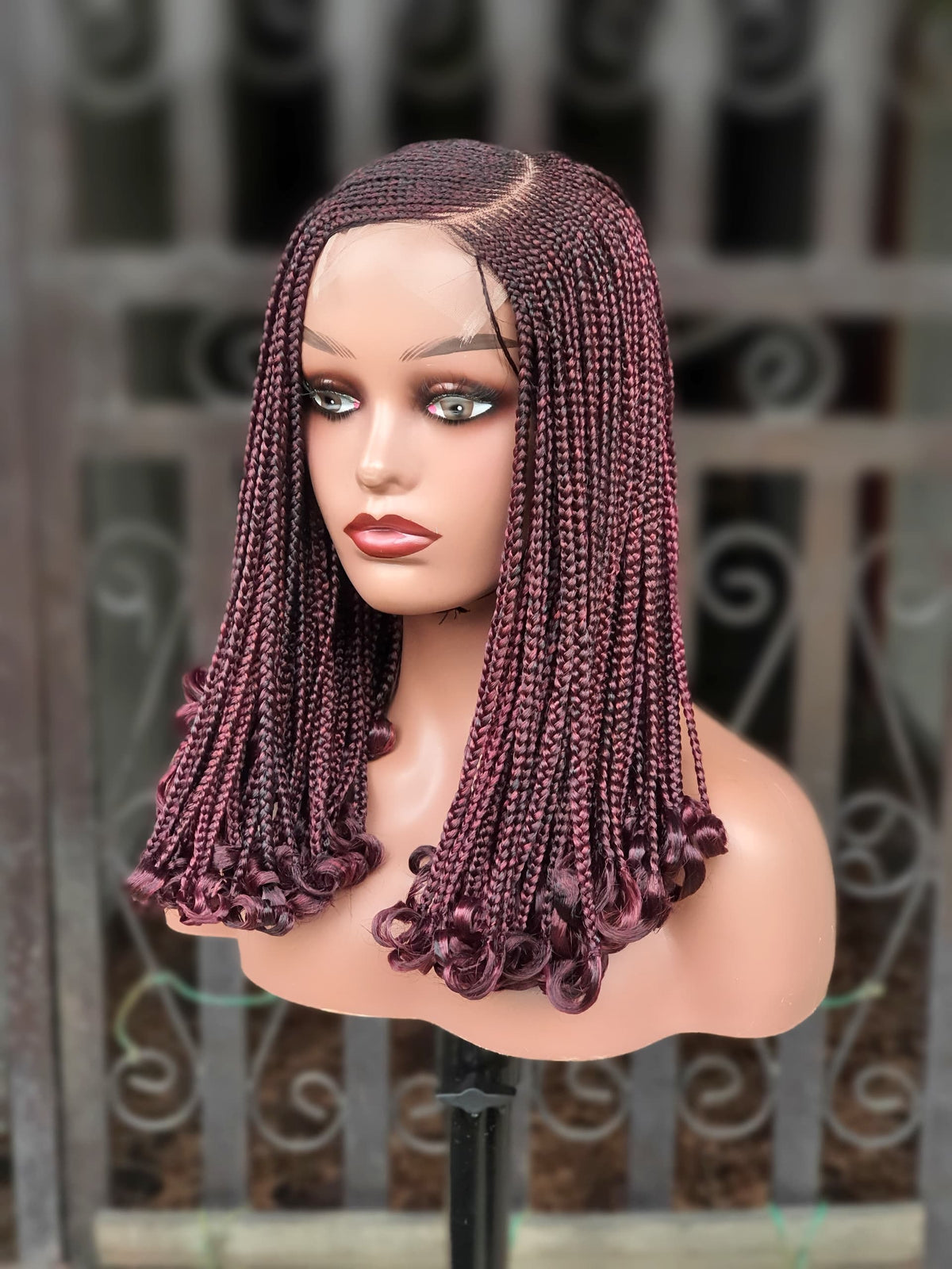 Three-quarter view of burgundy 16 inch C-cut cornrow wig with curled ends
