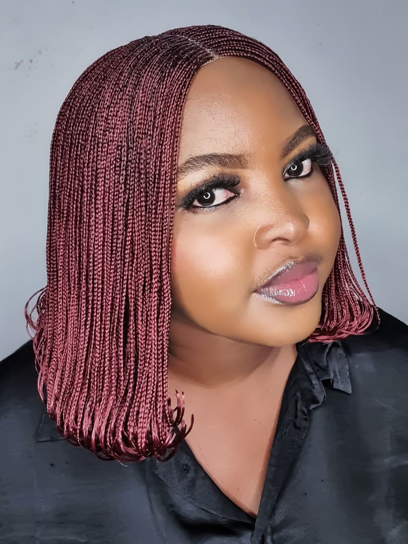 Close side view of burgundy bob braided wig with softly curled ends
