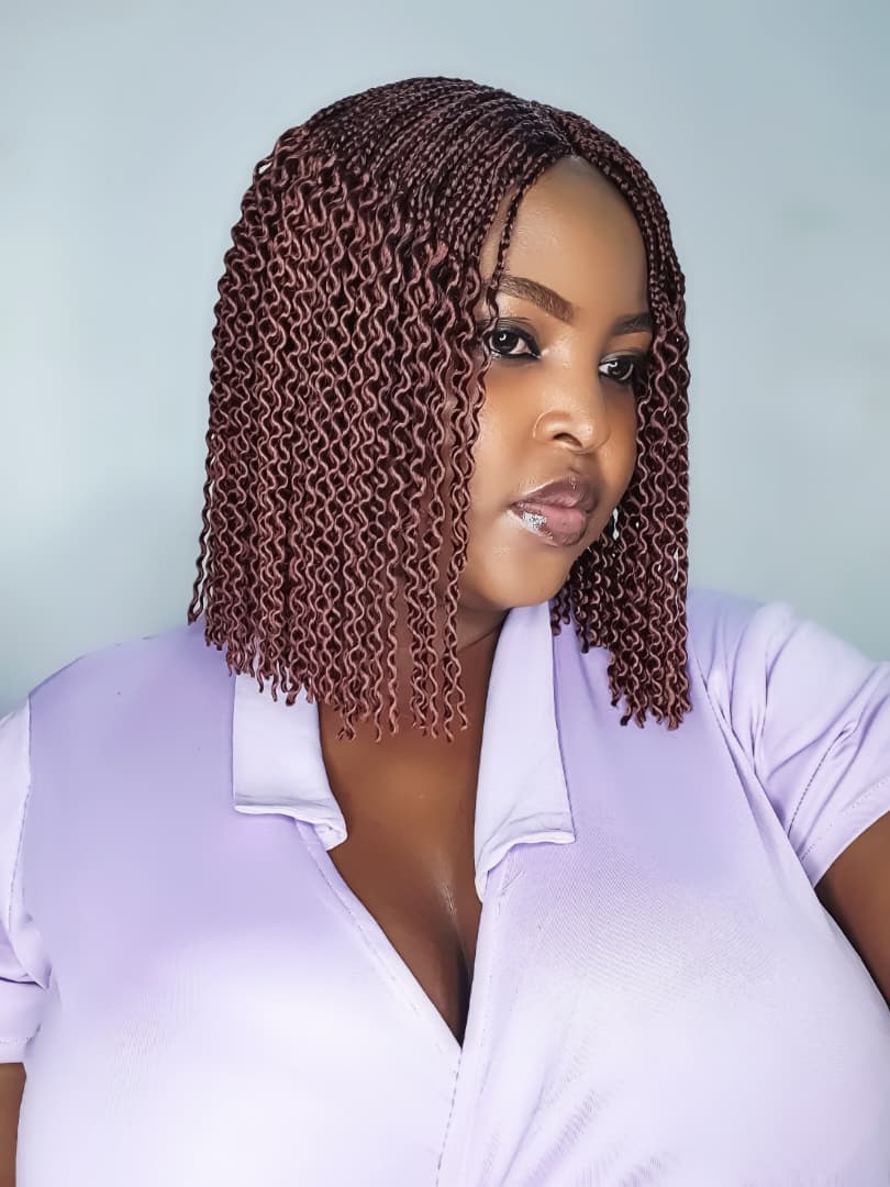 Woman wearing short colour 35 watermelon braid wig, angled view